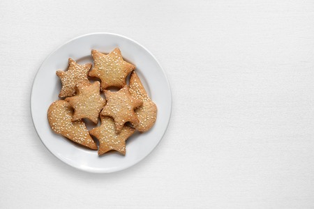 Cookies with sesame in plate on white wooden tableの写真素材
