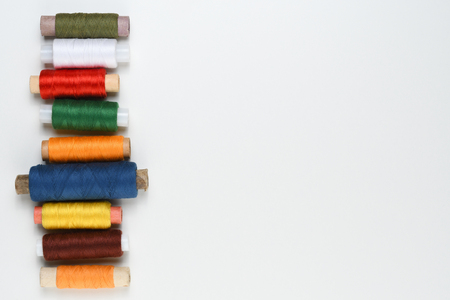 Spools of thread on white table top view