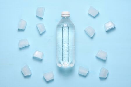 Water bottle and ice pieces on blue table top viewの写真素材