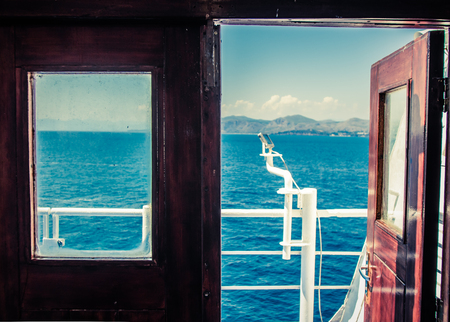 View of the sea from red vintage door on a ferry.の写真素材