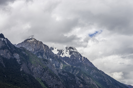 beautiful clouds and fog among frozen mountain summits landscapeの写真素材