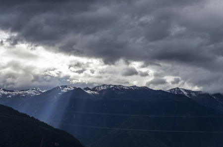 beautiful clouds and fog among frozen mountain summits landscapeの写真素材