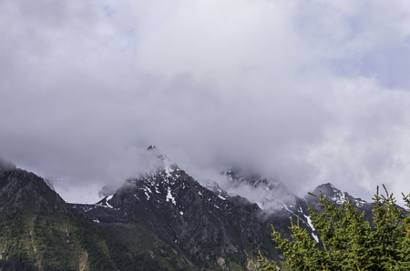 beautiful clouds and fog among frozen mountain summits landscapeの写真素材