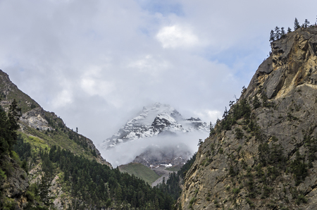 beautiful clouds and fog among frozen mountain summits landscapeの写真素材