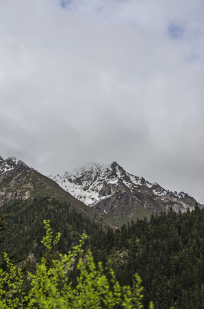 beautiful clouds and fog among frozen mountain summits landscapeの写真素材