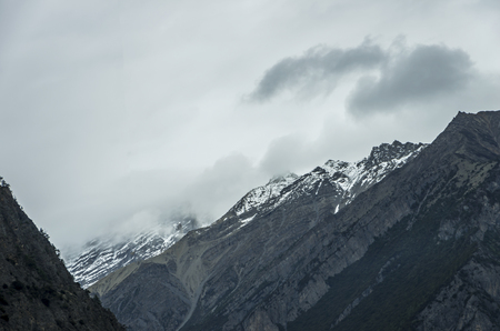 beautiful clouds and fog among frozen mountain summits landscapeの写真素材
