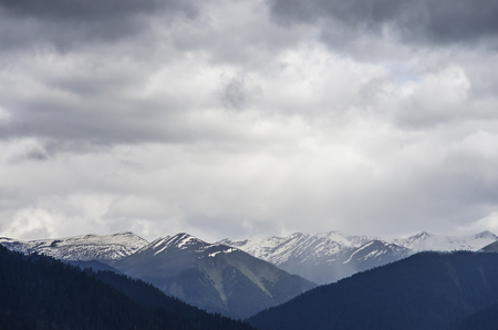 beautiful clouds and fog among frozen mountain summits landscapeの写真素材