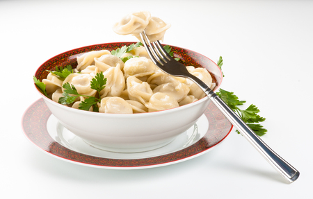 dumplings in a plate with a fork, parsley and butterの写真素材