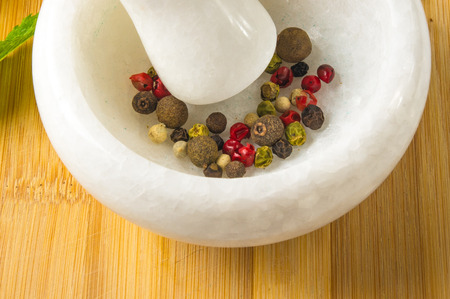 spices - a variety of allspice and star anise in a marble mortar on wooden backgroundの写真素材