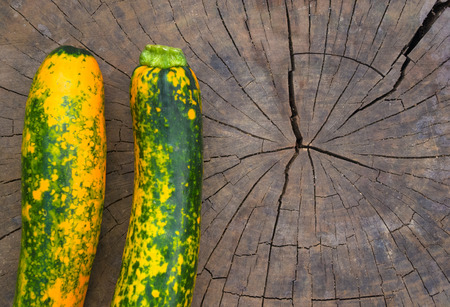 unusual green-orange zucchini on an old wooden backgroundの写真素材