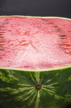 half of ripe watermelon on a black backgroundの写真素材