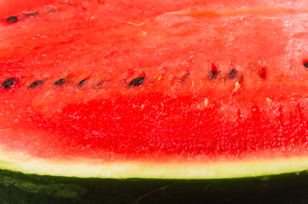 half of ripe watermelon on a black backgroundの写真素材