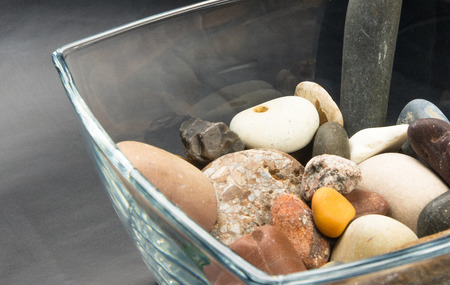 multicolored decorative pebbles in glass containers on a black backgroundの写真素材