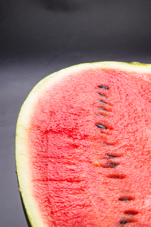 half of ripe watermelon on a black background