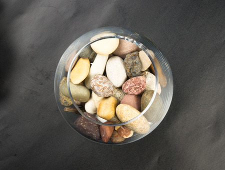 multicolored decorative pebbles in glass containers on a black backgroundの写真素材