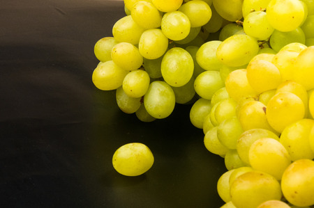 Large grapes cluster amber color on black background