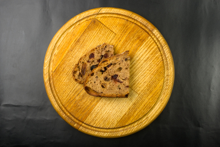 Slices of malt bread handmade with nuts, raisins and cranberries on wooden backgroundの写真素材