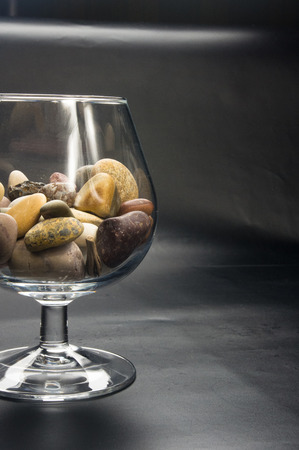 multicolored decorative pebbles in glass containers on a black backgroundの写真素材