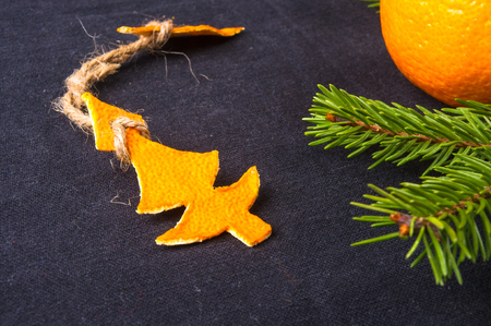 New Year Concept. Christmas decorations hand made from tangerine peel and fir-tree branches on black backgroundの写真素材