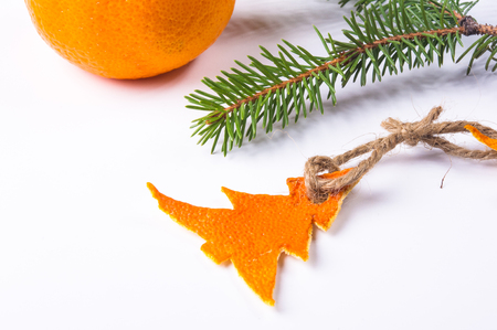 New Year Concept. Christmas decorations hand made from tangerine peel and fir-tree branches on white backgroundの写真素材