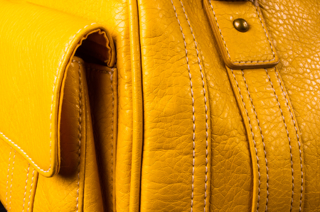 closeup of buckles, clasps, zippers, pockets, fasteners, fittings and seams on yellow leather hand bagの写真素材