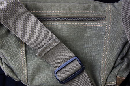 closeup of buckles, clasps, zippers, pockets, fasteners, fittings and seams on the hand bag of coarse cotton fabricの写真素材