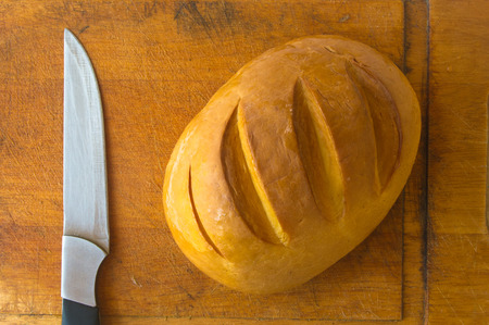 head of traditional Adygei cheese handmade with knife on wooden Board