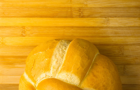 fresh braided loaf of white wheat bread on bamboo wooden backgroundの写真素材
