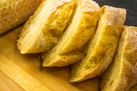 fresh sliced loaf of white wheat bread on wooden backgroundの写真素材