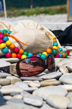 beach bag and sunglasses on pebble beach, sunsetの写真素材