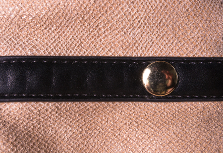 closeup of buckles, clasps, zippers, pockets, fasteners, fittings and seams on brown leather hand...
