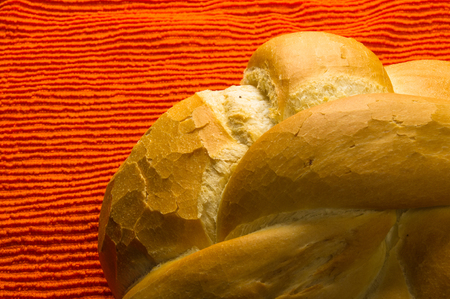 fresh braided loaf of white wheat bread on an orange napkinの写真素材