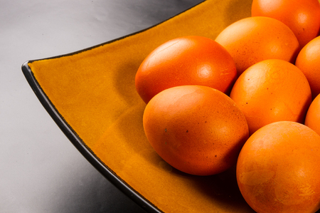 eggs colored with natural dye on brown dishの写真素材