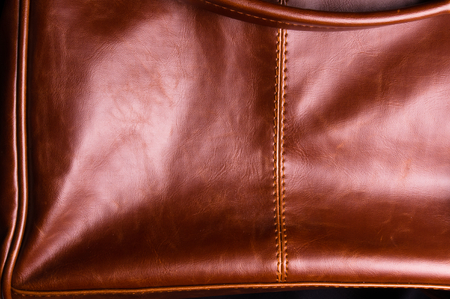 closeup of buckles, clasps, zippers, pockets, fasteners, fittings and seams on brown leather vintage hand bagの写真素材