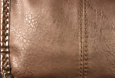 closeup of buckles, clasps, zippers, pockets, fasteners, fittings and seams on brown leather hand bagの写真素材