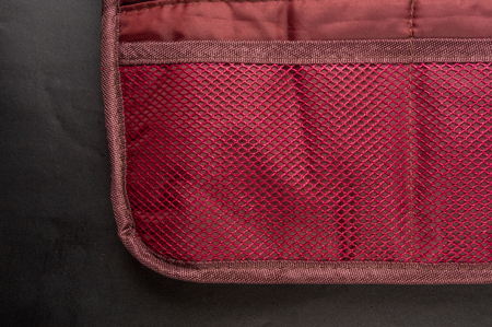 Burgundy travel bag organizer with pockets from mesh fabric, close-upの写真素材