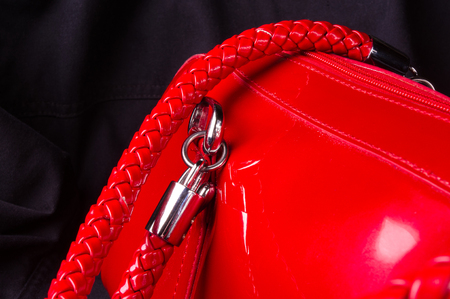 closeup of buckles, clasps, zippers, pockets, fasteners, fittings and seams on the red lacquer hand bagの写真素材