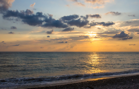 Summer sea sunset, the sun, waves and clouds, beautiful dramatic lightingの写真素材
