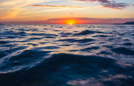 Summer sea sunset, the sun, waves and clouds, beautiful dramatic lightingの写真素材
