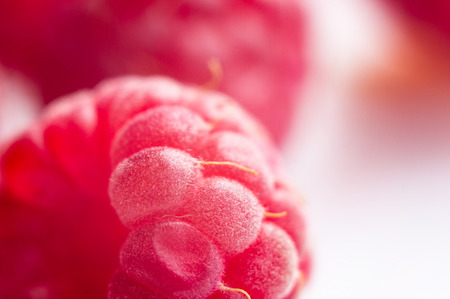 big fresh juicy raspberries on a white saucer close up, macro photo, selected focusの写真素材