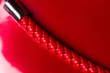 closeup of buckles, clasps, zippers, pockets, fasteners, fittings and seams on the red lacquer hand bagの写真素材