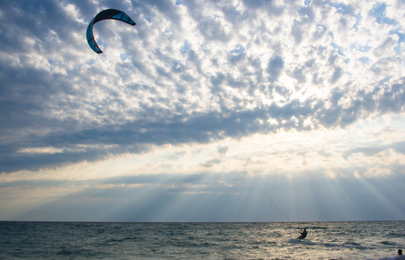 kitesurfer rides a kite-surf on waves of the sea in a small storm on a summer day