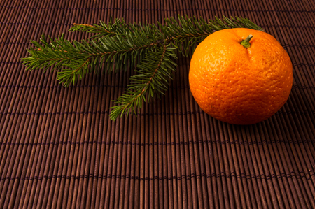 New Year Concept. Christmas decorations from fir-tree branches and the fruits of mandarin orange on bamboo mat backgroundの写真素材