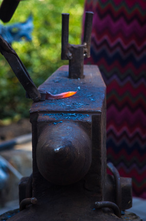 blacksmith performs the forging of hot glowing metal on the anvil, close-upの写真素材