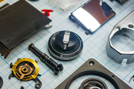 parts are completely disassembled old retro film SLR camera on graph paper, close-upの写真素材