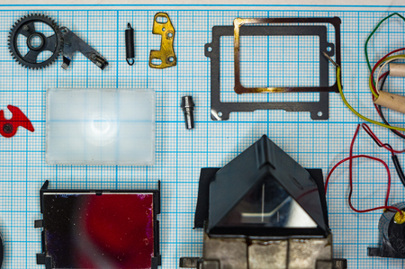 parts are completely disassembled old retro film SLR camera on graph paper, close-up