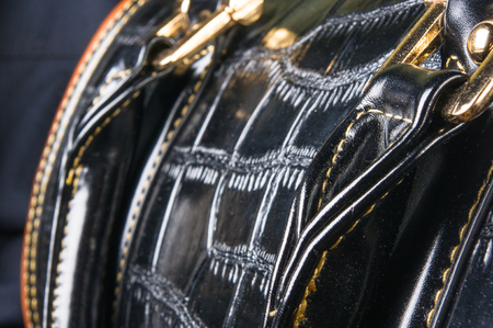 closeup of buckles, clasps, zippers, pockets, fasteners, fittings and seams on black leather hand bagの写真素材