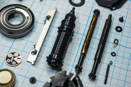 parts are completely disassembled old retro film SLR camera on graph paper, close-up
