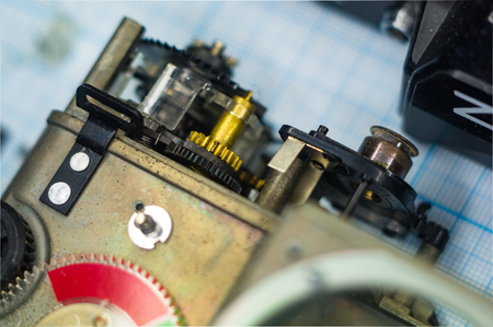 parts are completely disassembled old retro film SLR camera on graph paper, close-up
