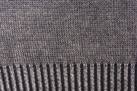 texture of a washed thick knit fabric, with decorative elements, seams and stitching, close-up